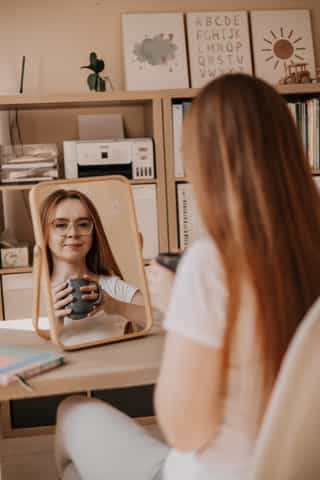 Zdjęcie przedstwiające kobietę odbijającą się w lusterku